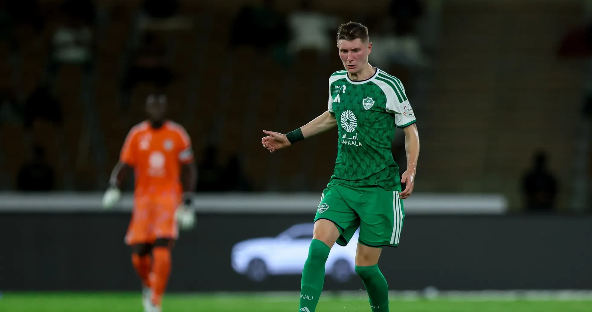 Player in green kit controlling the ball on field
