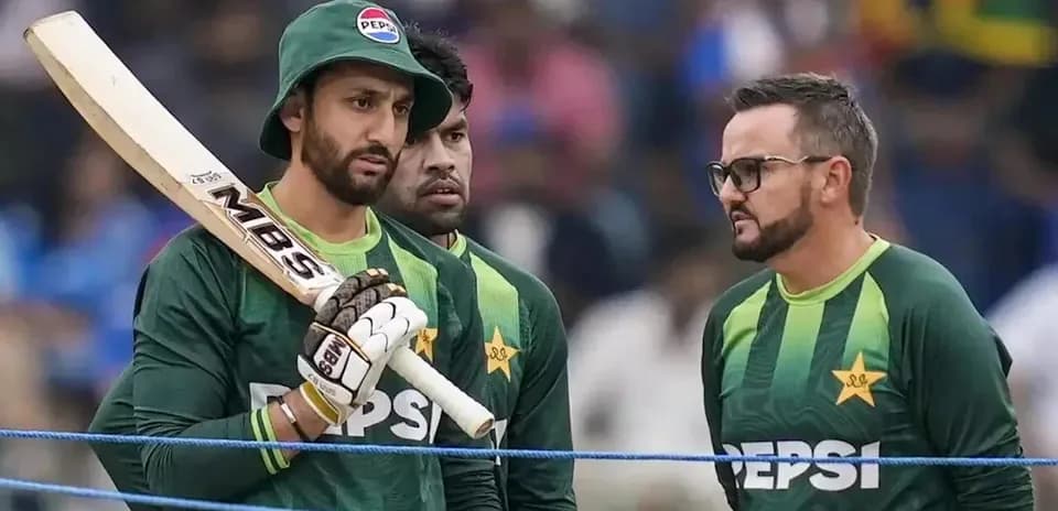 Pakistani cricket players discussing strategy on field