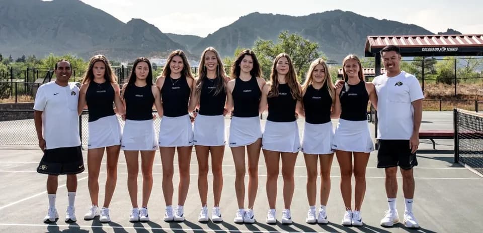 Tennis team posing on court with coaches