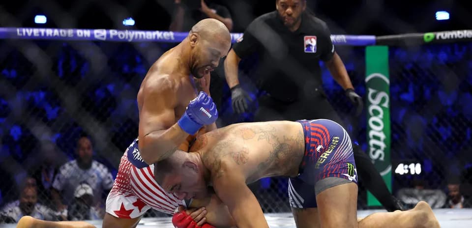 Fighters grappling in MMA match inside the cage