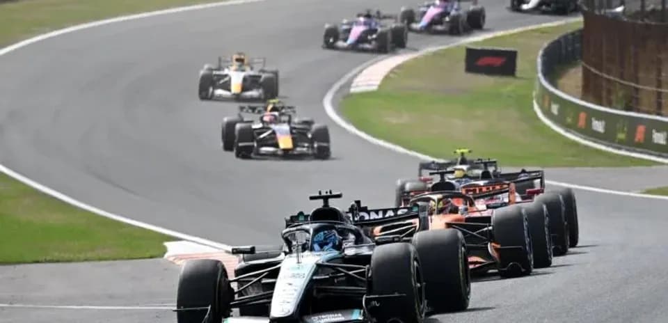 Formula 1 cars racing on a winding track