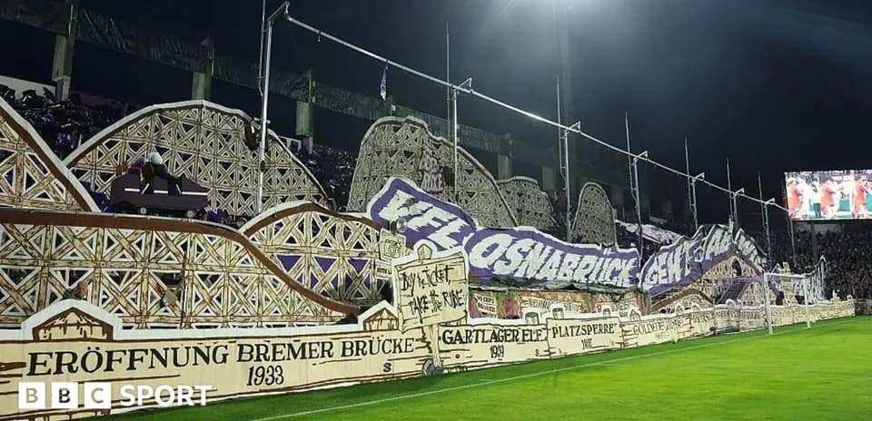 Fans displaying a large banner at the stadium