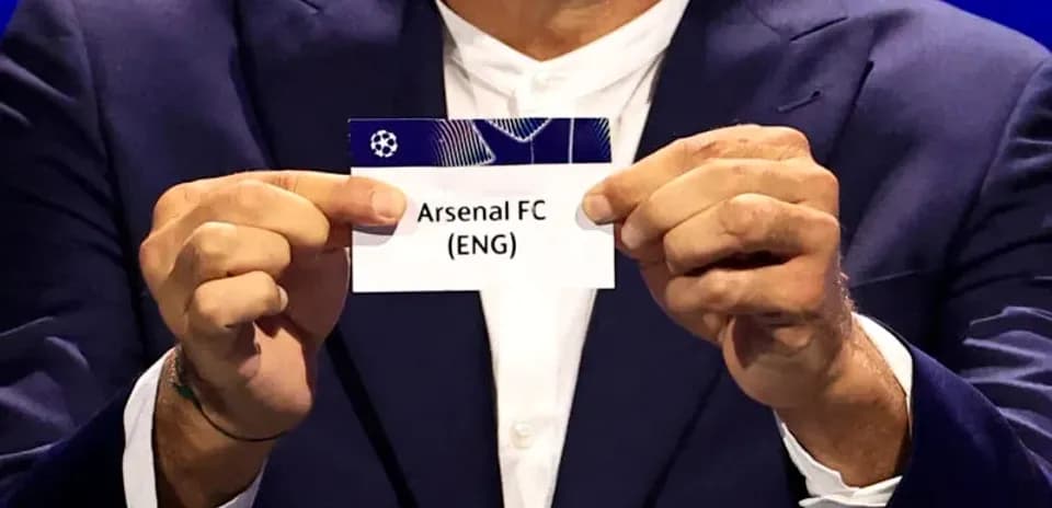 Official holding Arsenal FC draw card at event