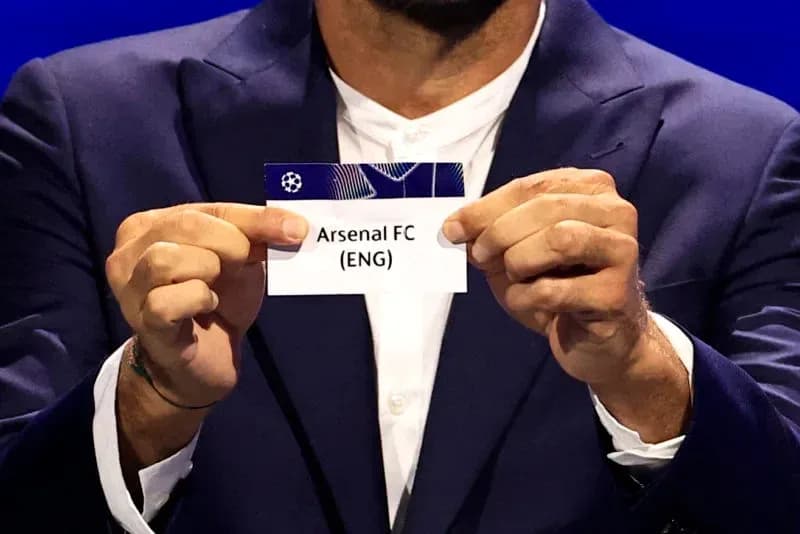Official holding Arsenal FC draw card at event