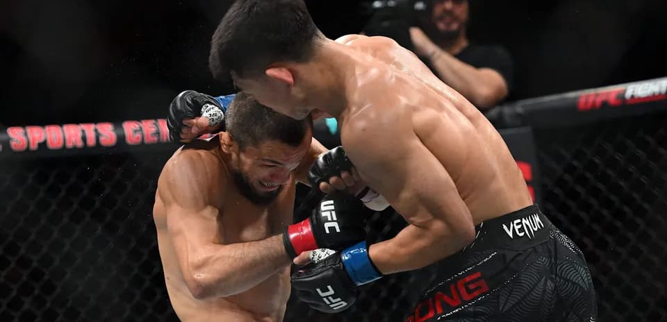 Two fighters engaged in close combat during match