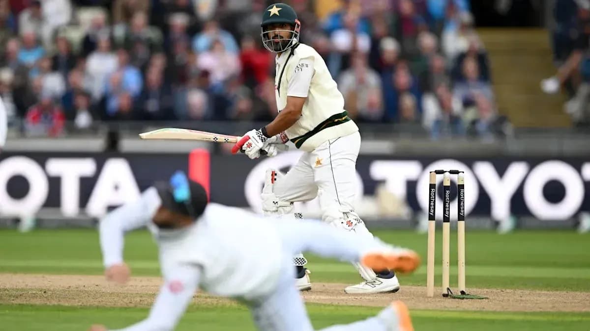 Batsman playing shot while fielder dives in cricket match
