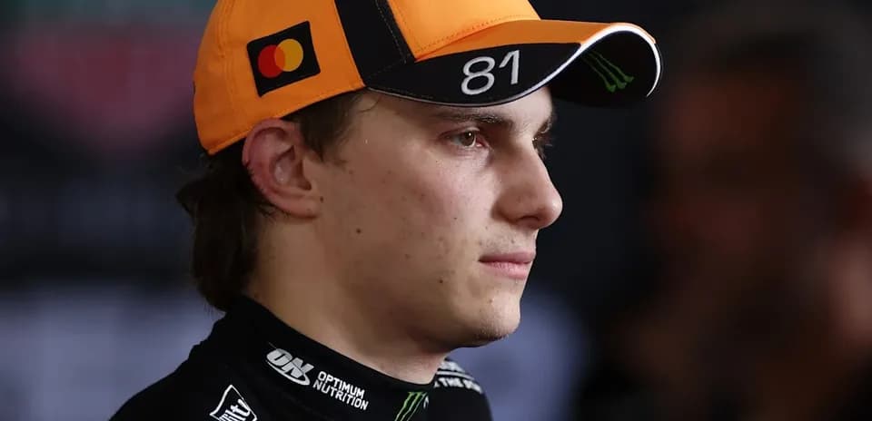 Driver wearing an orange cap during press event