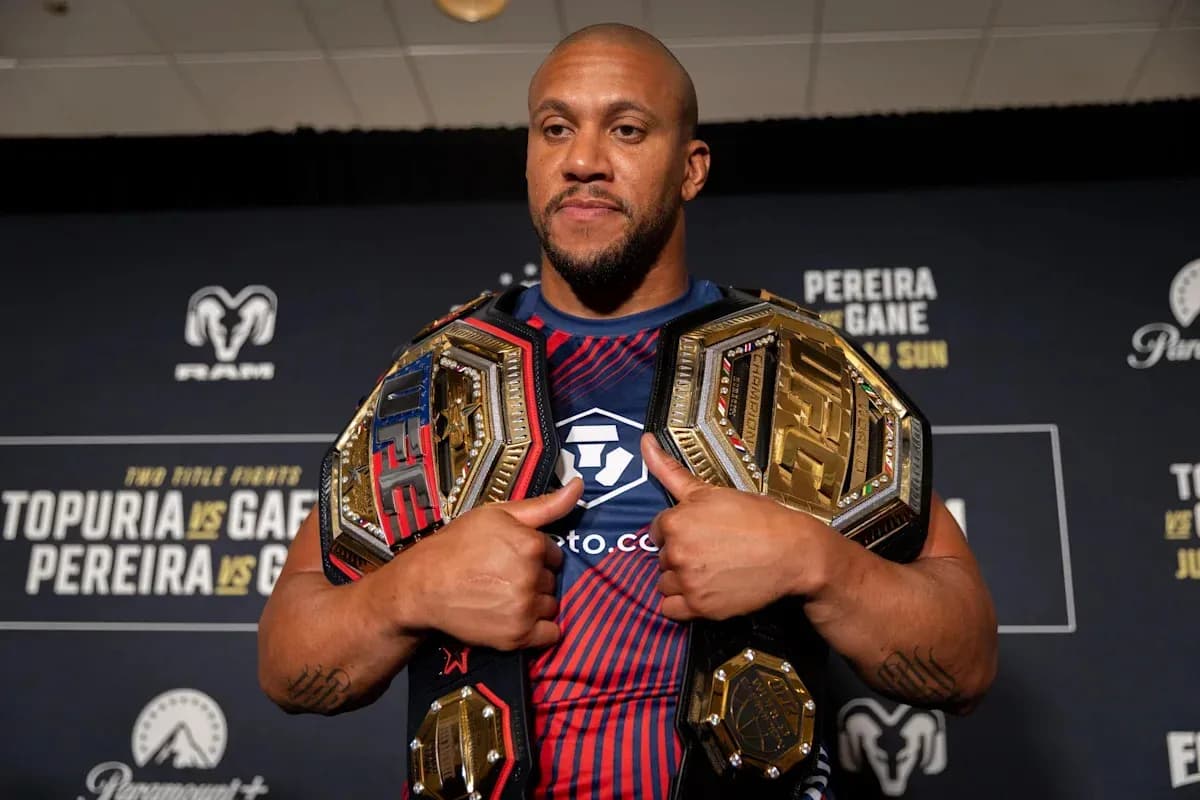 Fighter displaying two championship belts at event