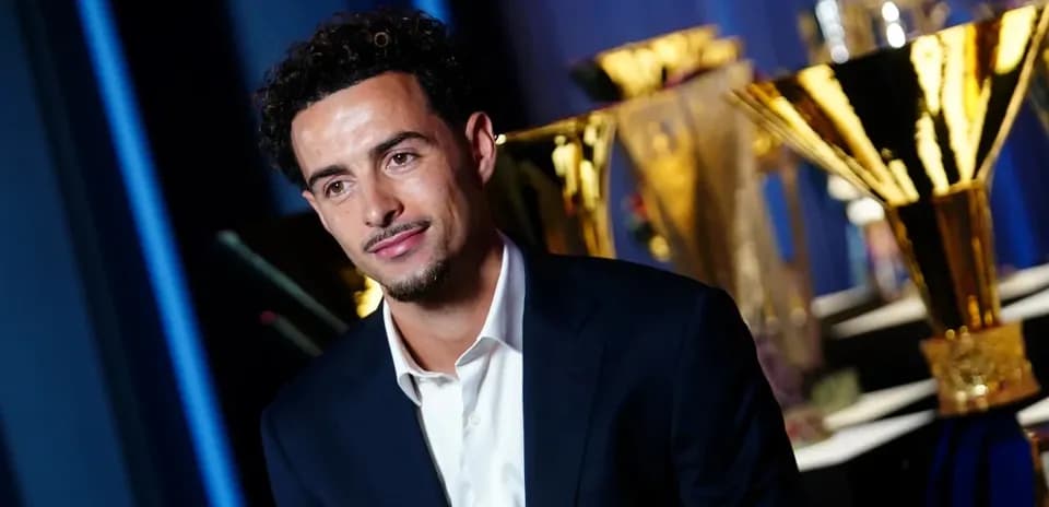 Player posing with trophies in background