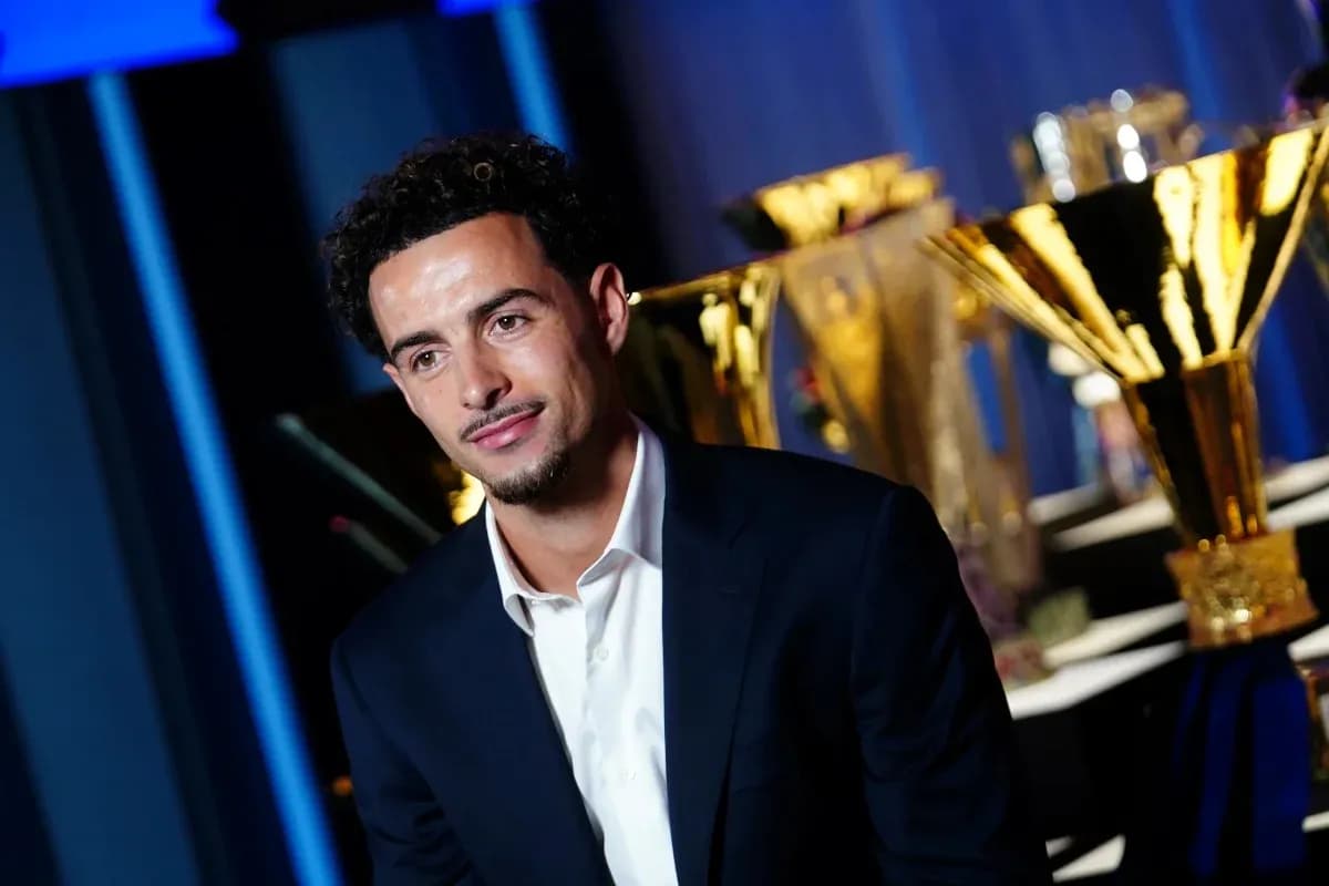 Player posing with trophies in background