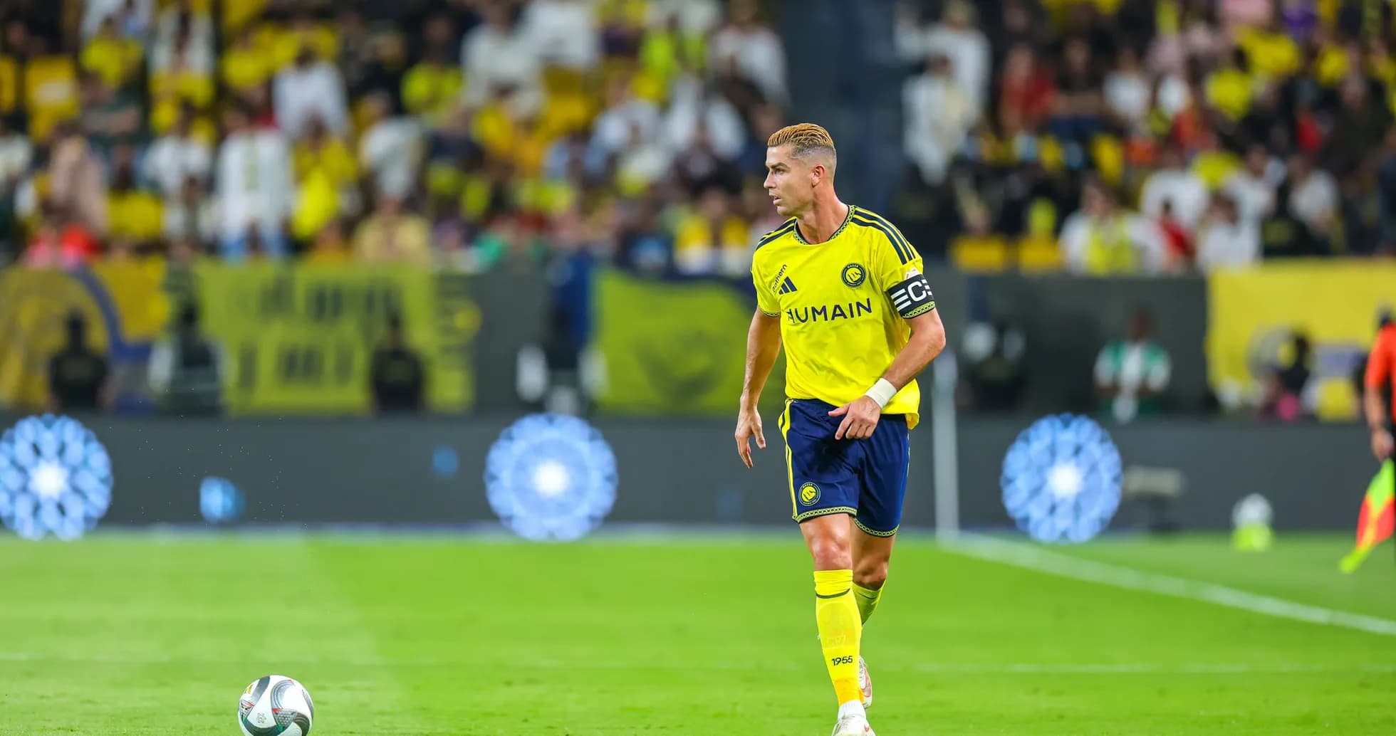 Player in yellow jersey walking on field with ball