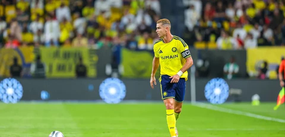 Player in yellow jersey walking on field with ball