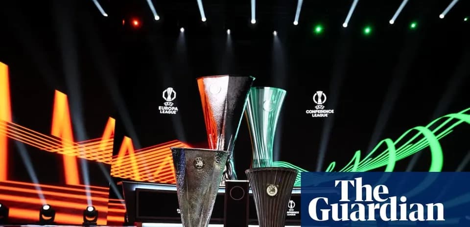 Three UEFA trophies on stage with lighting effects