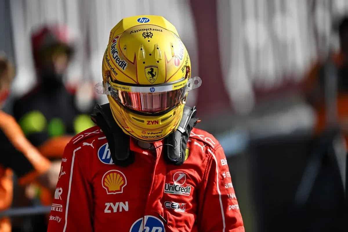 Driver in Ferrari suit wearing helmet on pit lane