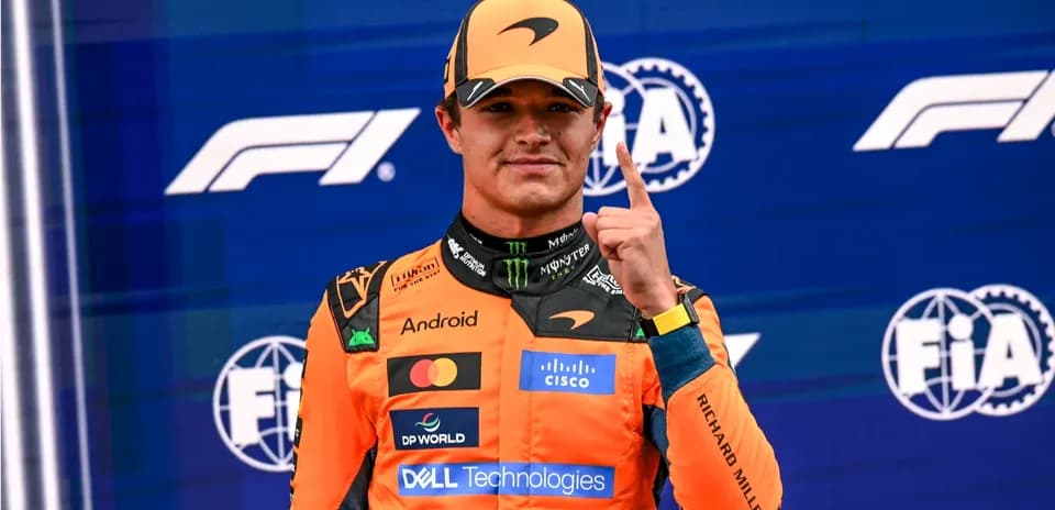 Driver celebrating with finger raised on podium