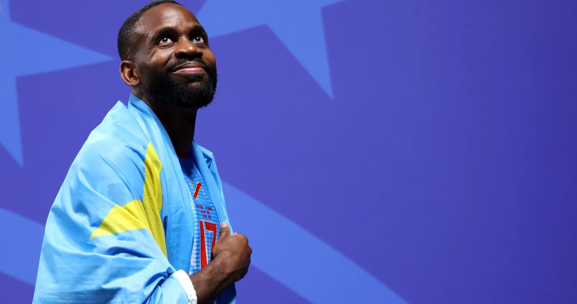 Athlete wearing a flag, looking up during event