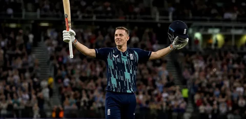 Batsman celebrating with bat and helmet raised