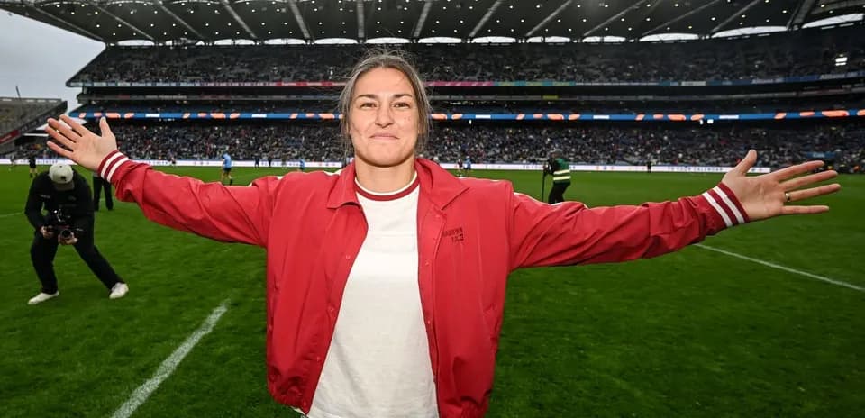 Woman in red jacket celebrating on the pitch