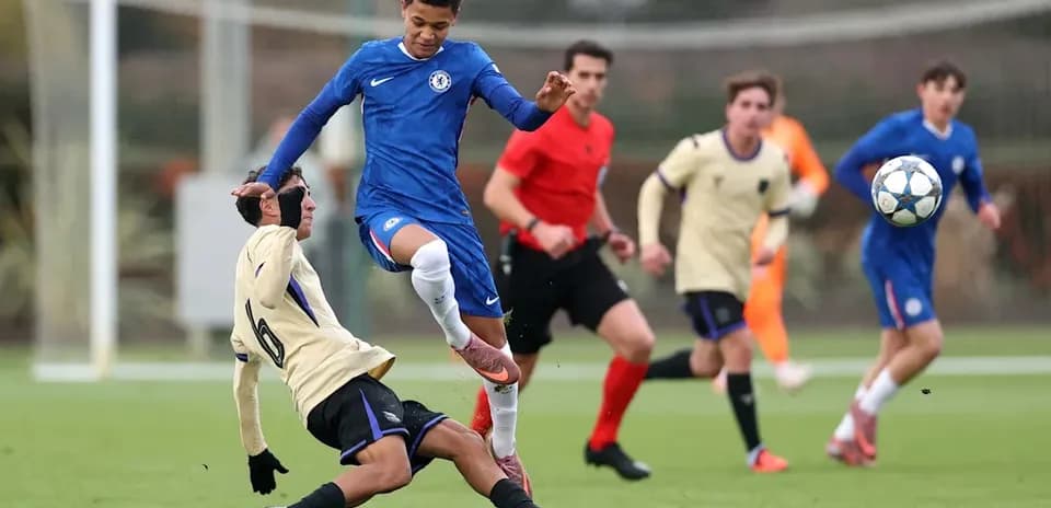 Player in blue evading tackle during youth football match