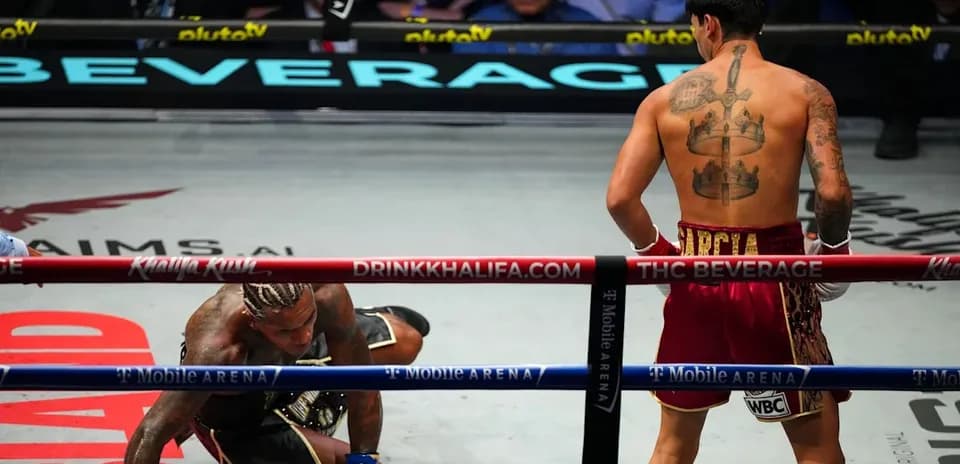 Boxer on the canvas, opponent standing in ring