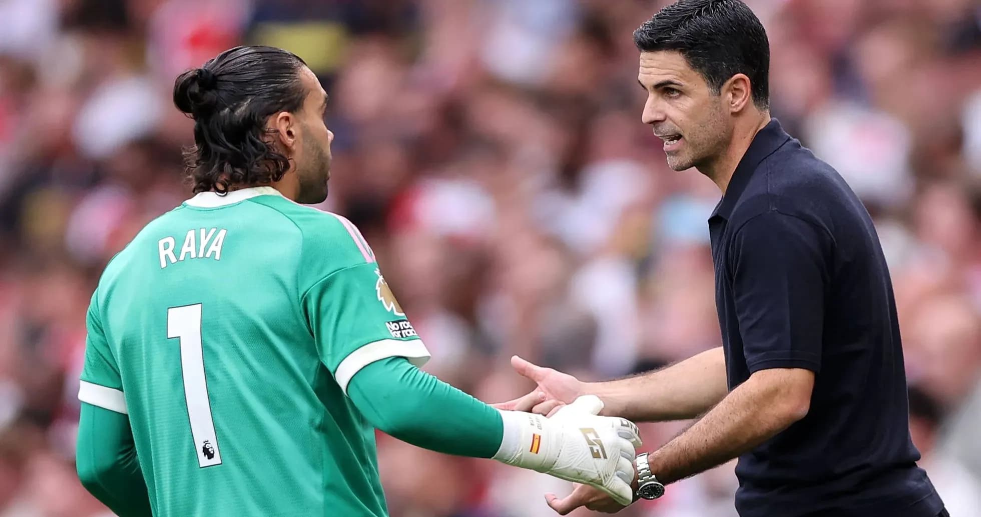 Goalkeeper and coach discussing strategy during match