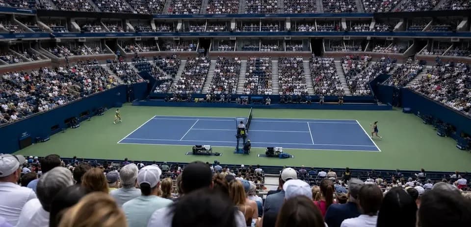 Tennis match in stadium with large crowd