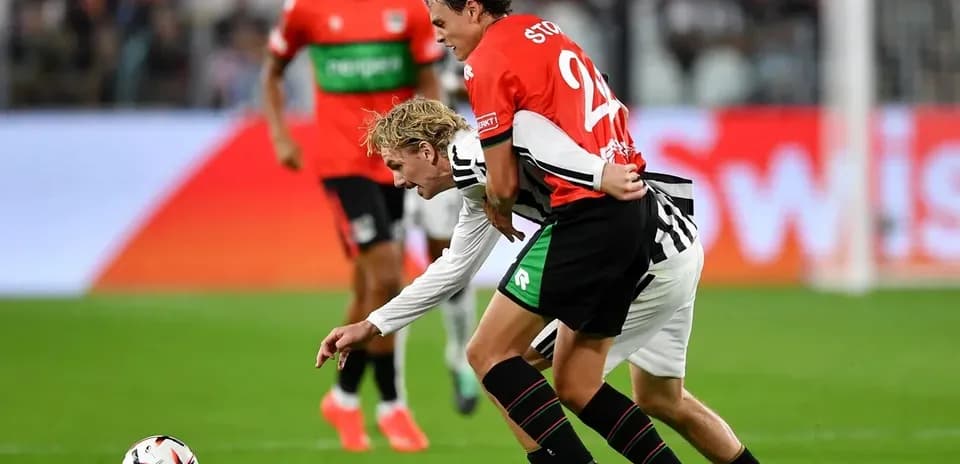 Two players competing for the ball on field