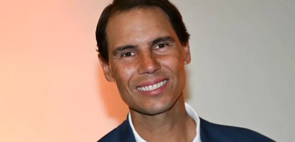 Man smiling in a suit against a light background