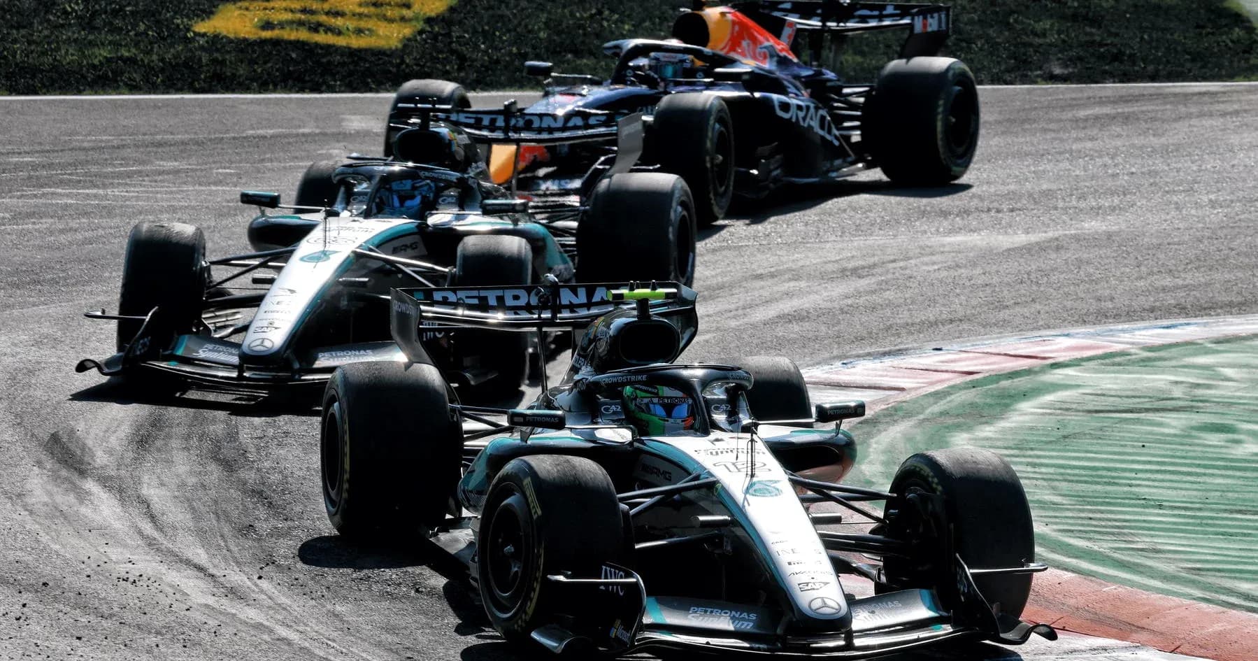 Three Formula 1 cars racing on track