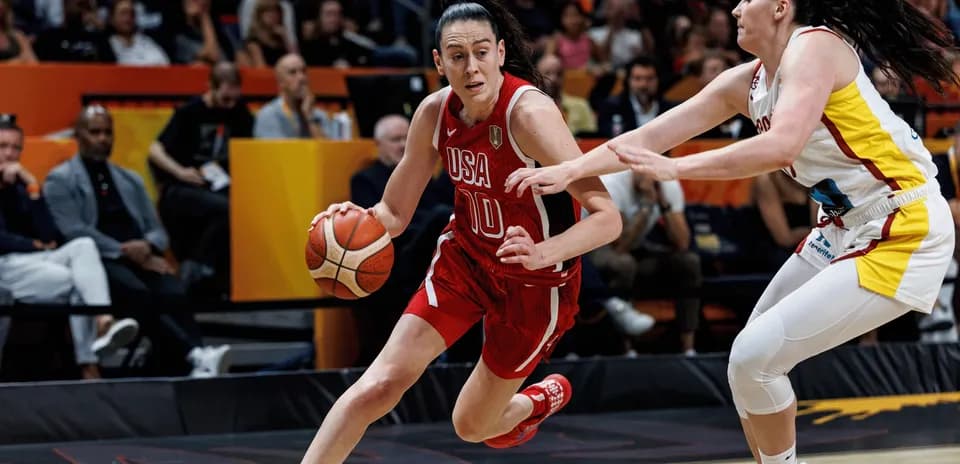 USA player dribbling past defender in basketball game