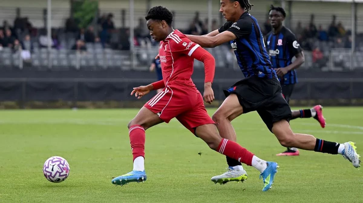 Player in red dribbling past opponent in blue