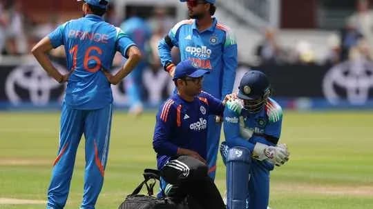Cricket players and coach discussing injury on field