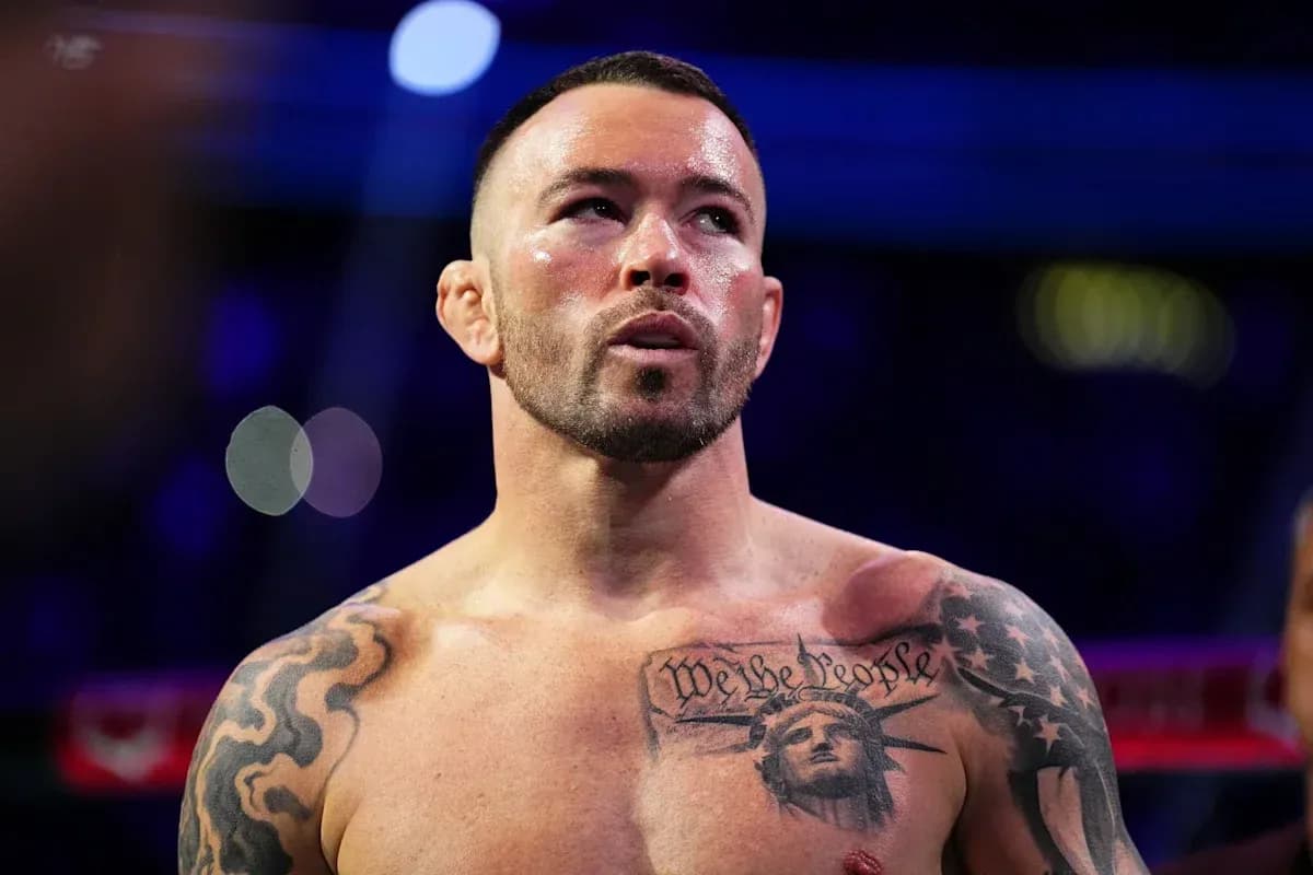 Fighter with tattoos in boxing ring, focused expression