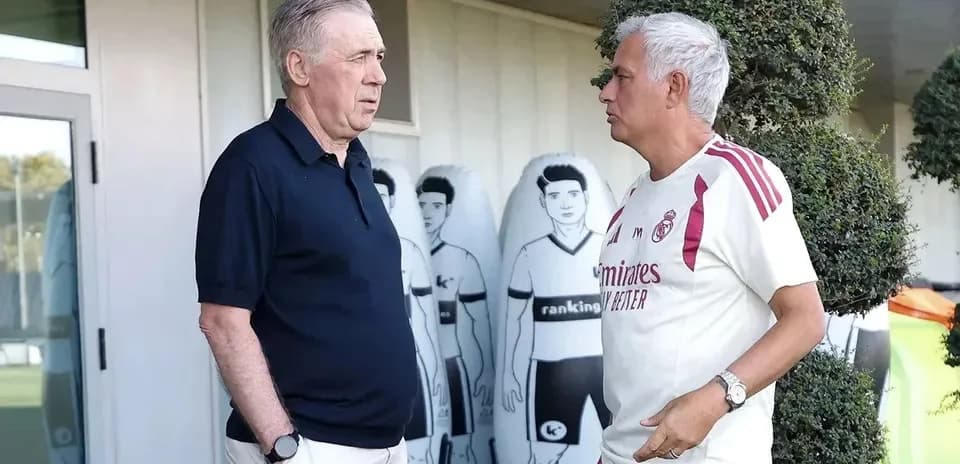 Coaches discussing at training ground with mannequins