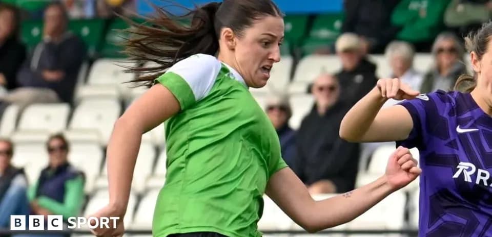 Player in green dribbling past opponent in purple