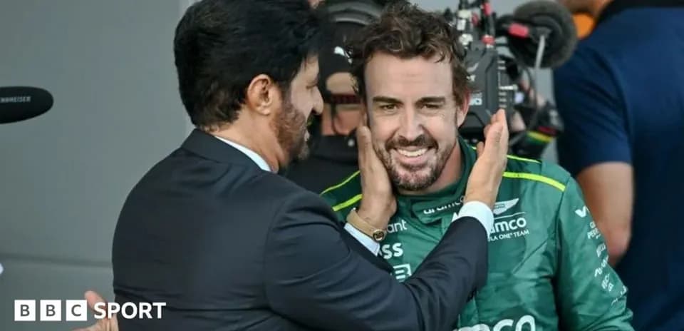 Fernando Alonso smiling with a team representative