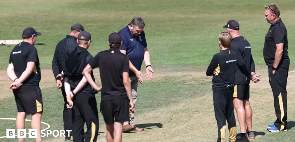 Coaching staff discussing strategy on cricket field