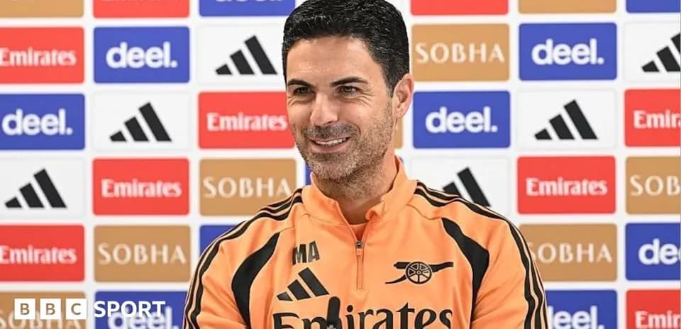 Manager speaking at press conference with sponsor backdrop
