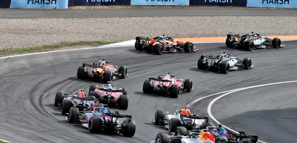 Multiple Formula 1 cars racing around a corner