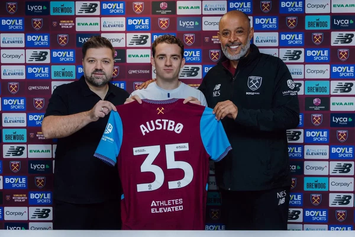 Player holding jersey with two officials at signing event