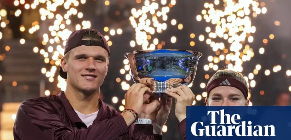 Two players holding trophy with fireworks in background