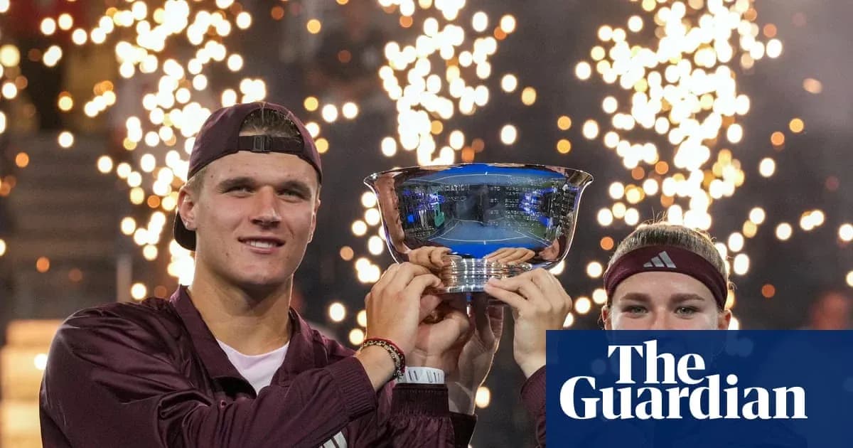 Two players holding trophy with fireworks in background