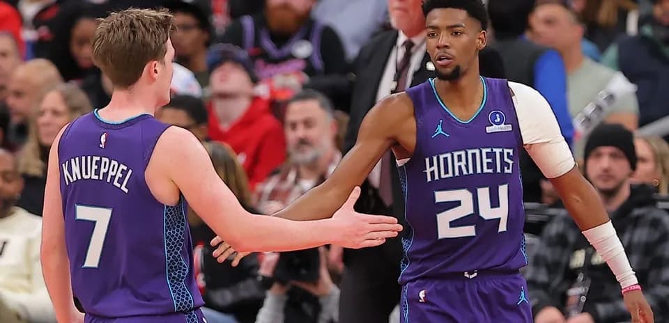 Two Charlotte Hornets players greeting each other on court