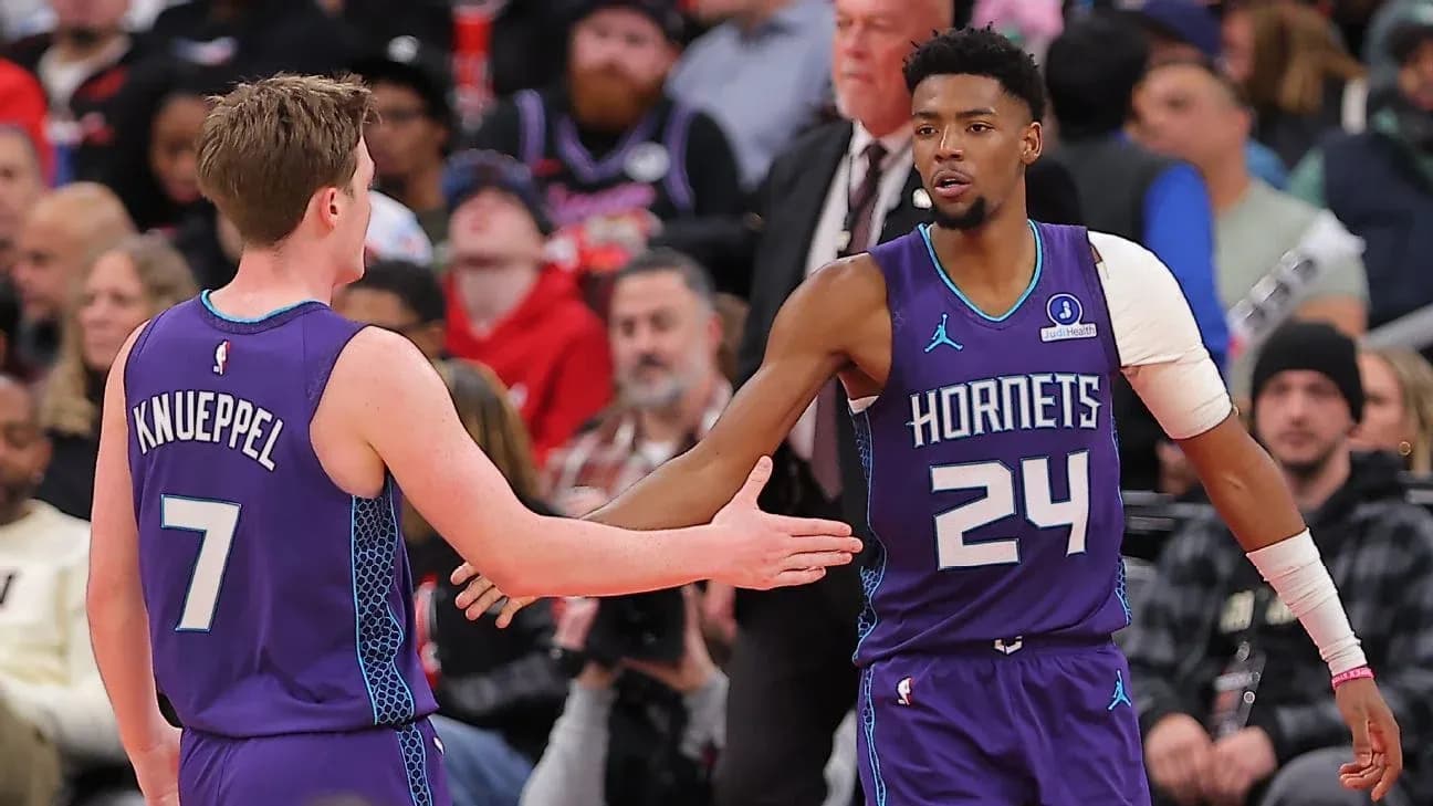Two Charlotte Hornets players greeting each other on court