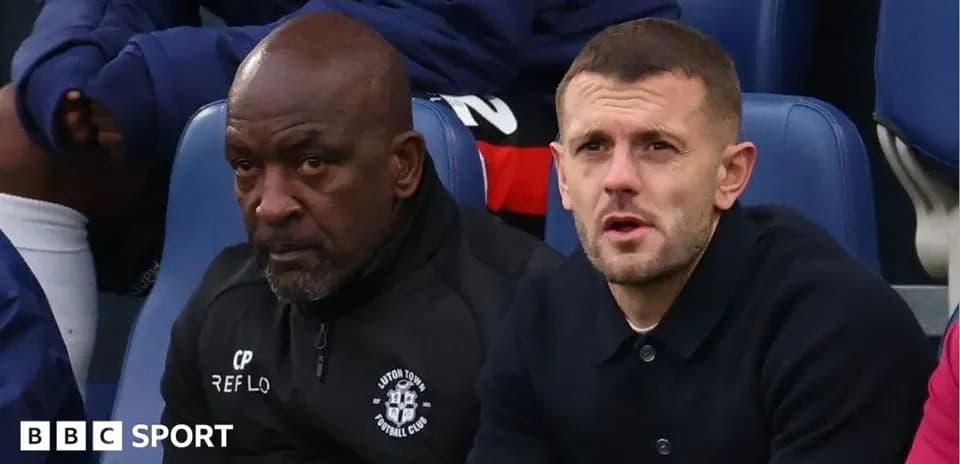 Two men sitting on team bench during match