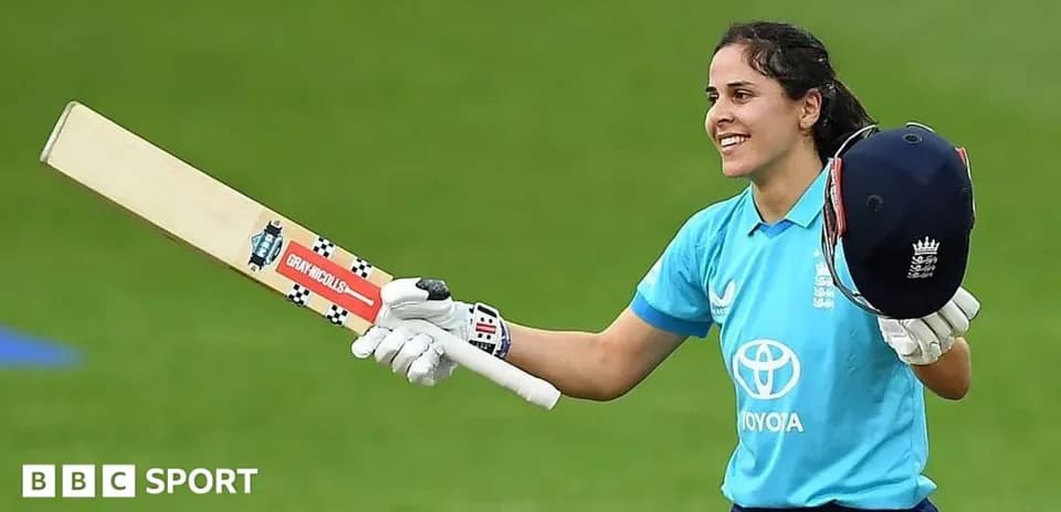 Cricketer celebrating with bat and helmet raised