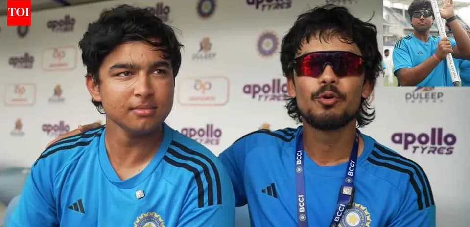 Two cricket players in blue jerseys at press conference