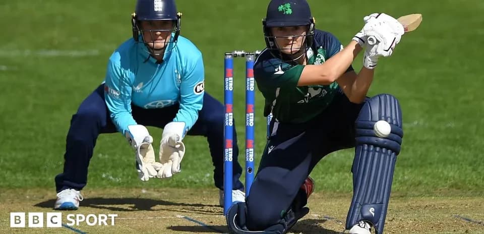 Batter playing a shot while wicketkeeper crouches