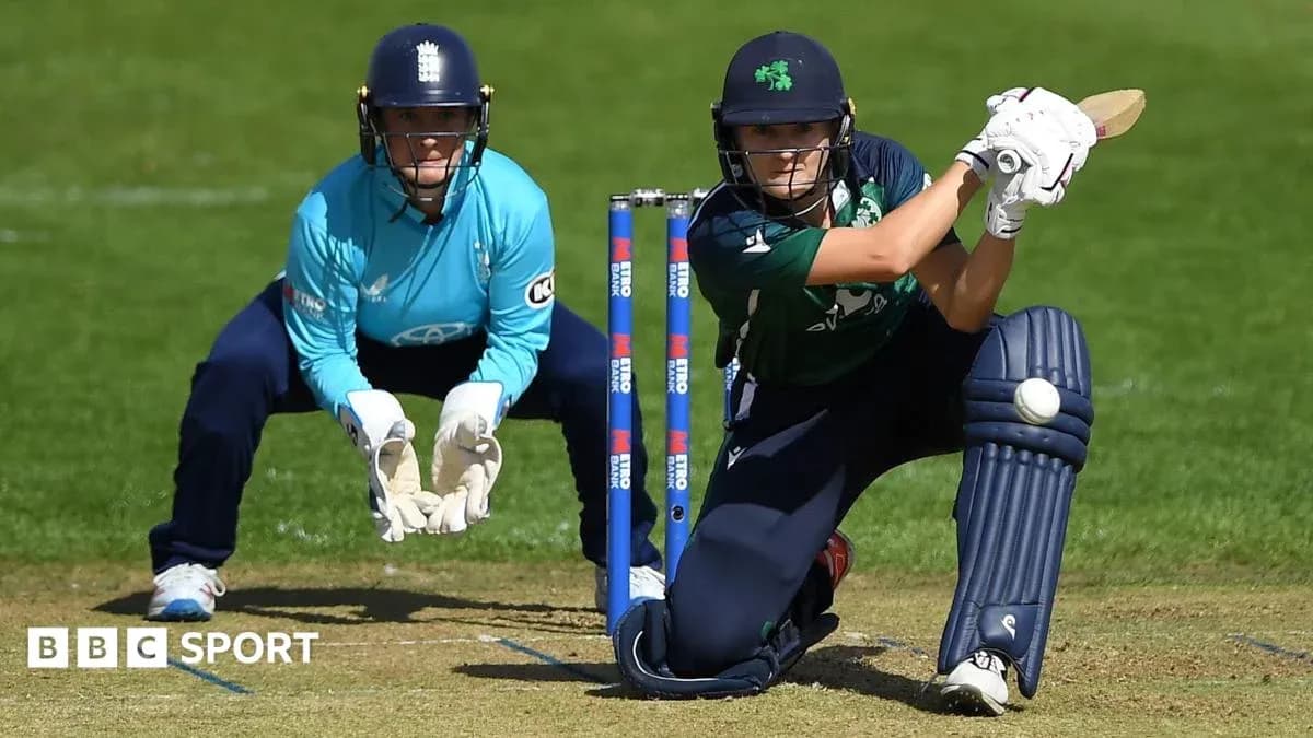 Batter playing a shot while wicketkeeper crouches