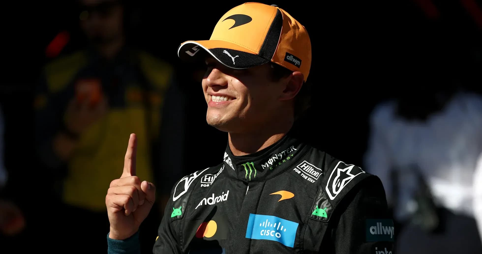Driver celebrating with finger raised in paddock